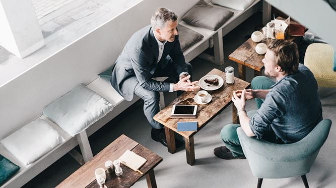 Ein Mann lässt sich zu den Laufzeiten und aktuellen Zinssätzen von Kassenobligationen beraten.