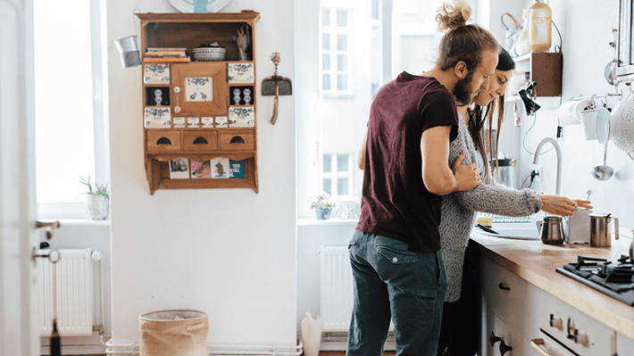 Ein junges Paar überlegt, ob sie weiterhin ihre Wohnung mieten oder ein Haus kaufen möchten.