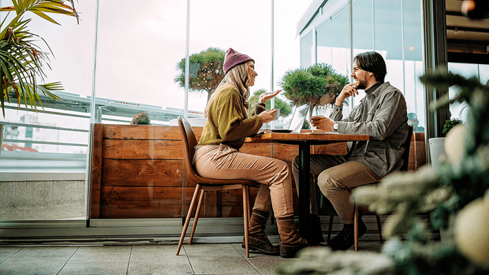 Symbolbild: Mia et Sven discutent au café des avantages des ETF et du large choix proposé par Zak Invest.
